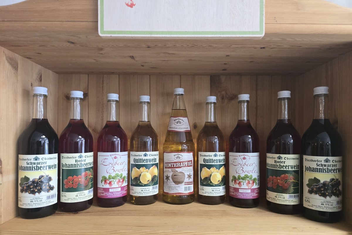 Eine Reihe Diesdorfer Obstweine im Holzregal.